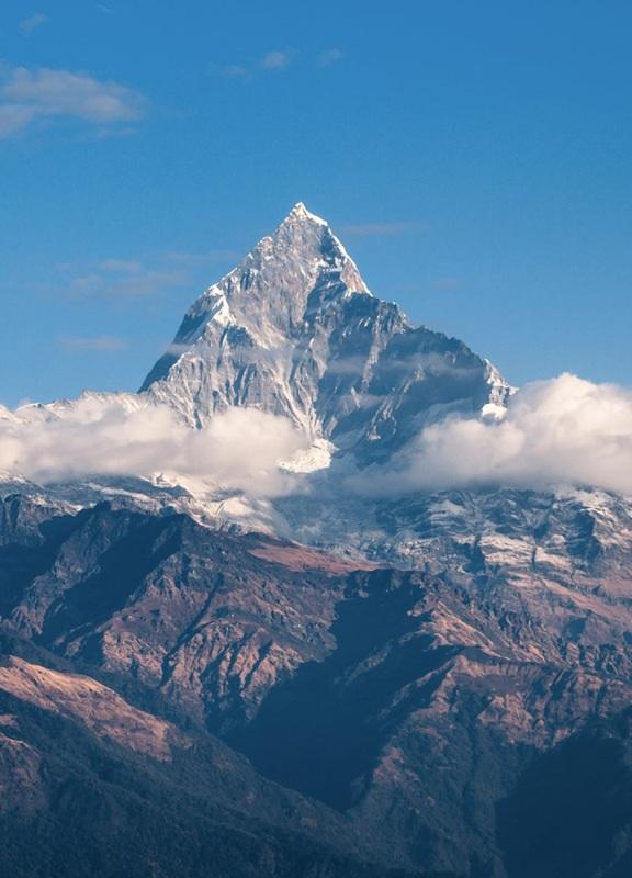 Snow-covered mountain range beneath a cloudy sky